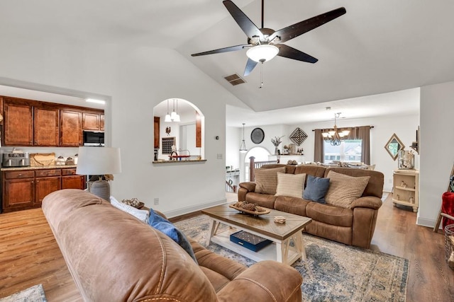 1464 Fieldstone Ct, Winder, GA 30680 - living area featuring lofted ceiling, ceiling fan, a chandelier, light wood-type flooring, and arched walkways