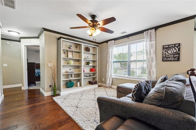 living room featuring ornamental molding, baseboards, a ceiling fan, and dark wood finished floors