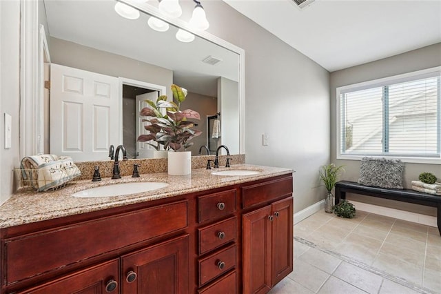 full bath featuring baseboards, double vanity, and tile patterned flooring