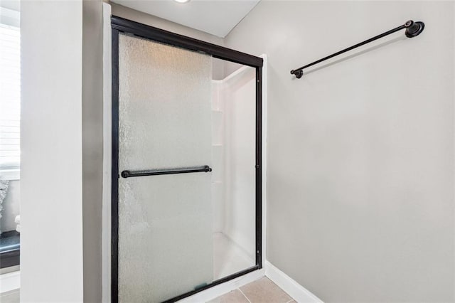 full bathroom with a stall shower and tile patterned floors