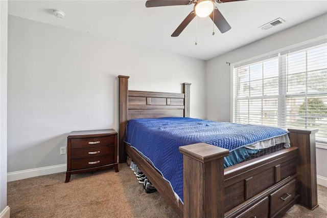 carpeted bedroom featuring multiple windows, baseboards, and ceiling fan