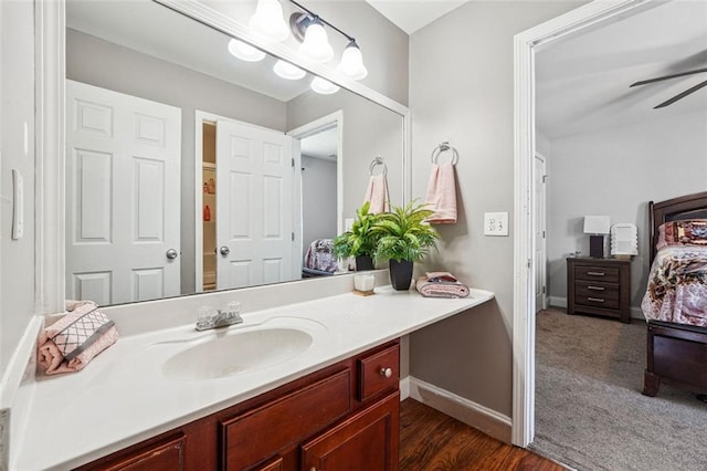bathroom featuring vanity, a ceiling fan, baseboards, and wood finished floors