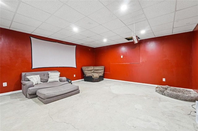 sitting room with baseboards, concrete floors, a paneled ceiling, and recessed lighting