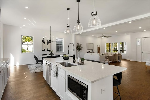 kitchen featuring sink, ceiling fan with notable chandelier, an island with sink, and appliances with stainless steel finishes