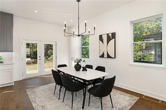 dining area featuring french doors, an inviting chandelier, and dark wood-type flooring