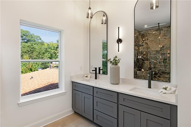 bathroom with vanity, a healthy amount of sunlight, and tiled shower