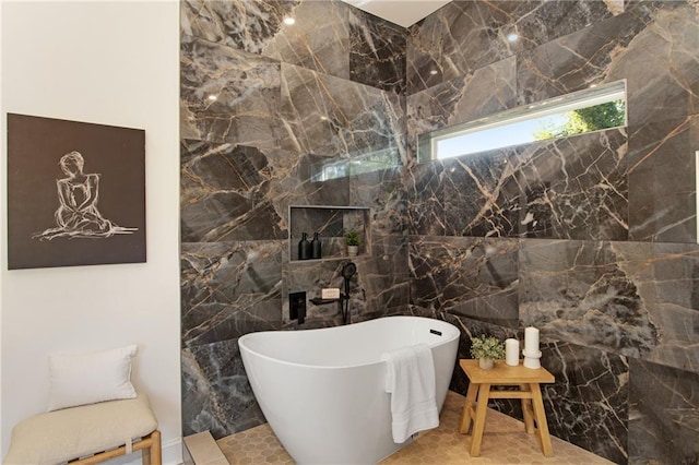 bathroom featuring tile walls, tile patterned floors, and a bath