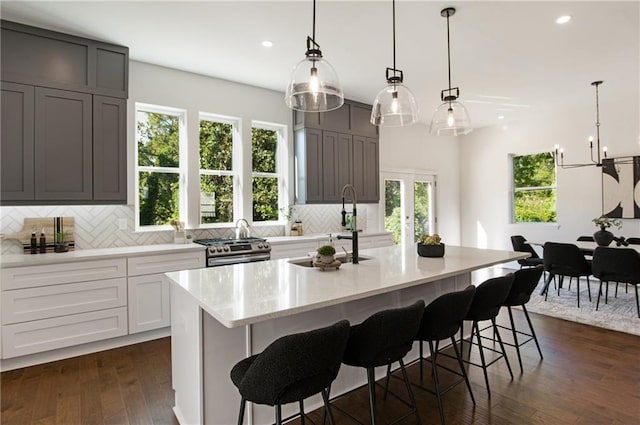 kitchen with gray cabinets, tasteful backsplash, pendant lighting, and a spacious island