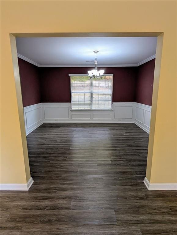 unfurnished dining area with ornamental molding, a chandelier, and dark hardwood / wood-style floors