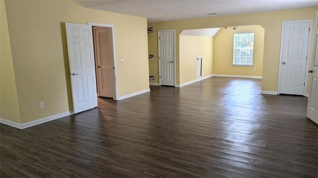 spare room with a textured ceiling and dark hardwood / wood-style floors