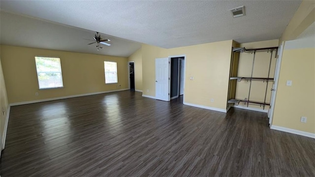 unfurnished living room featuring lofted ceiling, dark wood-type flooring, a textured ceiling, and ceiling fan