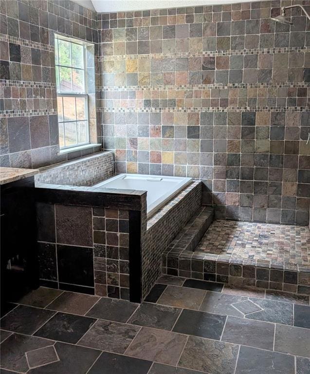 bathroom featuring tile walls and tiled bath