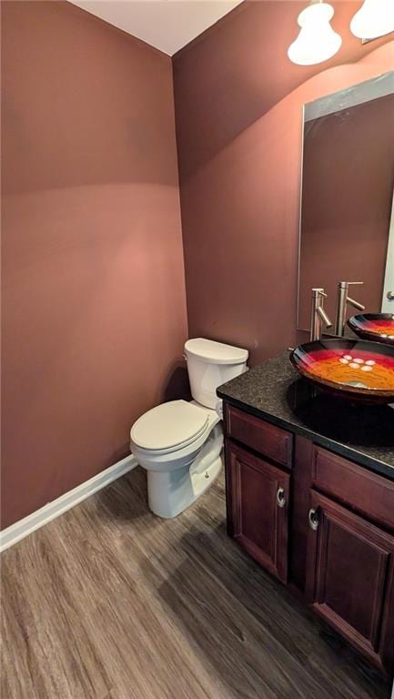 bathroom with vanity, wood-type flooring, and toilet