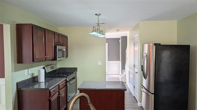 kitchen featuring a center island, hanging light fixtures, stainless steel appliances, and hardwood / wood-style flooring