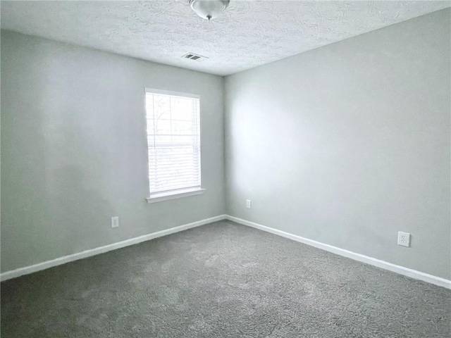 carpeted spare room with a textured ceiling