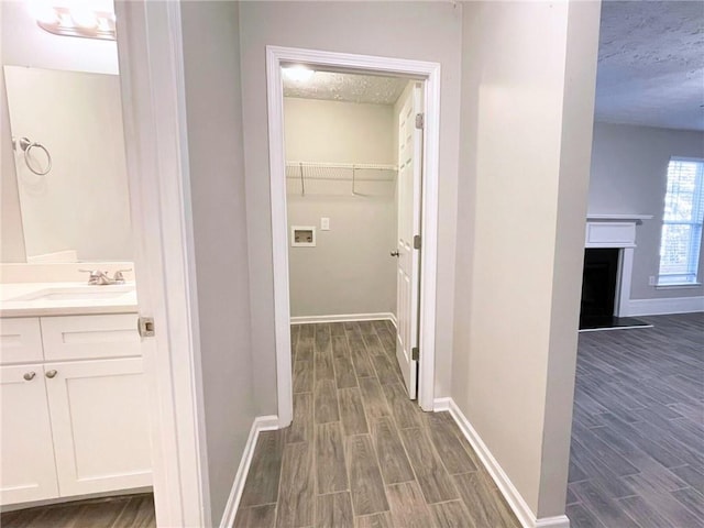 hall with sink and a textured ceiling