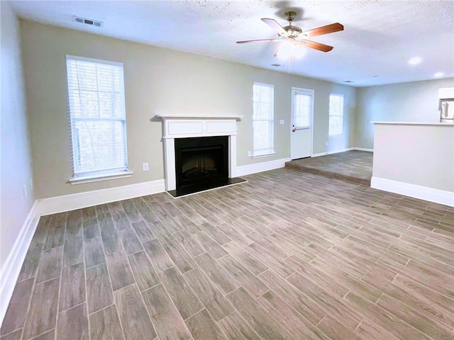 unfurnished living room with ceiling fan and wood-type flooring