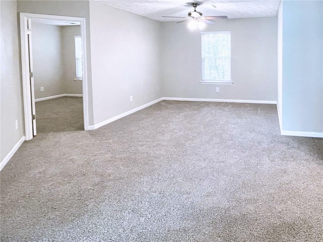 carpeted spare room featuring ceiling fan and a textured ceiling