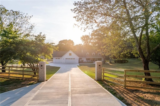 view of front of property featuring a fenced front yard, a garage, concrete driveway, and a front lawn