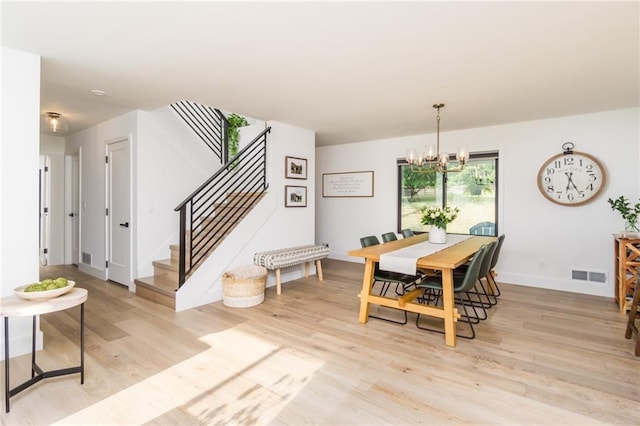 dining space with stairway, visible vents, baseboards, an inviting chandelier, and light wood-style floors