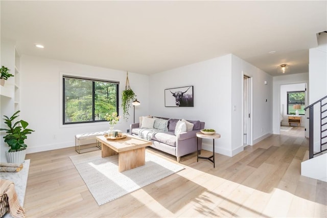 living room with recessed lighting, light wood-type flooring, and baseboards