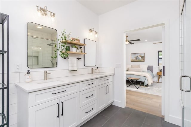 bathroom featuring a shower stall, ceiling fan, ensuite bathroom, tile patterned floors, and a sink