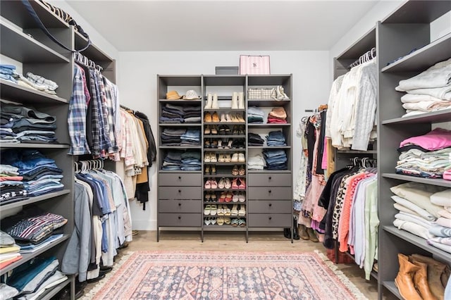 walk in closet with wood finished floors