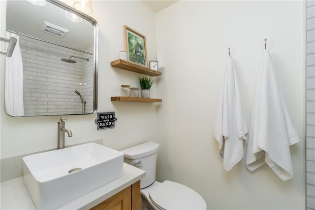 full bath featuring visible vents, toilet, walk in shower, and vanity