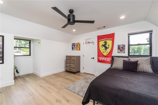 bedroom with light wood finished floors, visible vents, and lofted ceiling