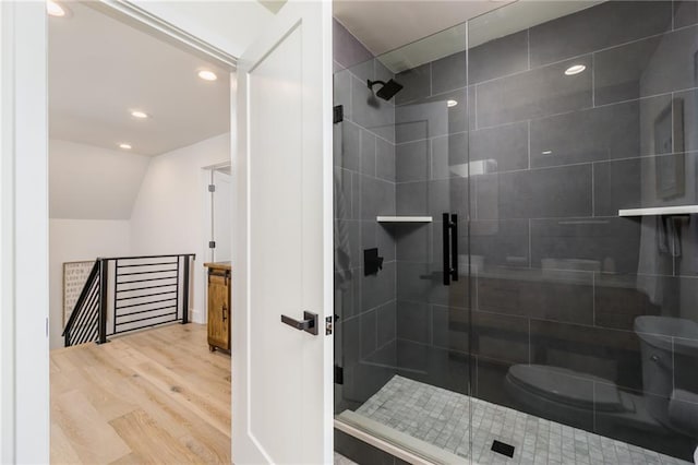 full bathroom featuring toilet, a stall shower, wood finished floors, recessed lighting, and lofted ceiling