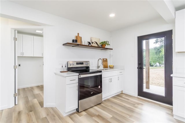 kitchen featuring white cabinetry, light wood-style flooring, light countertops, and electric stove