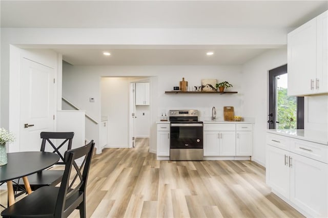 kitchen featuring open shelves, white cabinets, light wood-style floors, and stainless steel range with electric cooktop