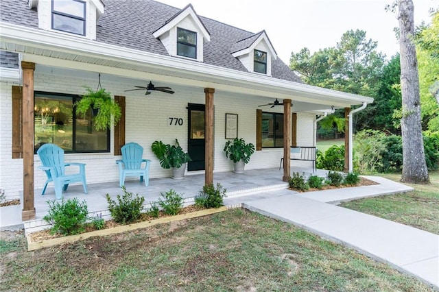 view of front of home featuring covered porch, brick siding, roof with shingles, and ceiling fan