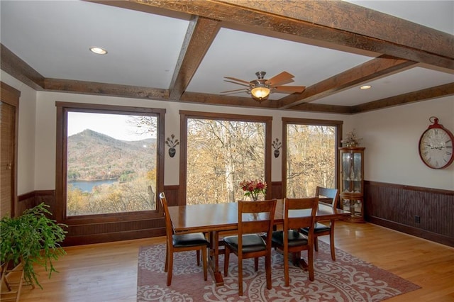 dining space with beamed ceiling, a mountain view, a wealth of natural light, and light wood-type flooring