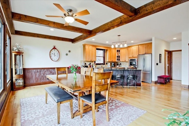 dining area with beam ceiling, ceiling fan, and light hardwood / wood-style floors