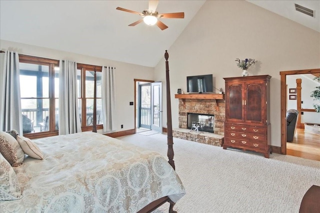 carpeted bedroom featuring ceiling fan, a stone fireplace, high vaulted ceiling, and access to exterior