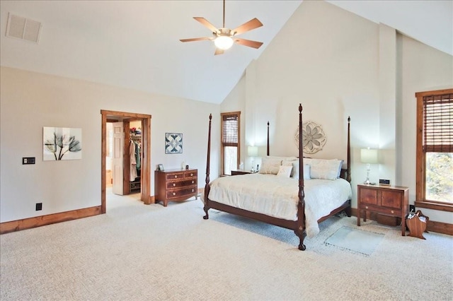 bedroom with ceiling fan, a walk in closet, light carpet, and high vaulted ceiling