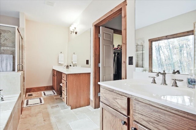 bathroom with vanity and shower with separate bathtub