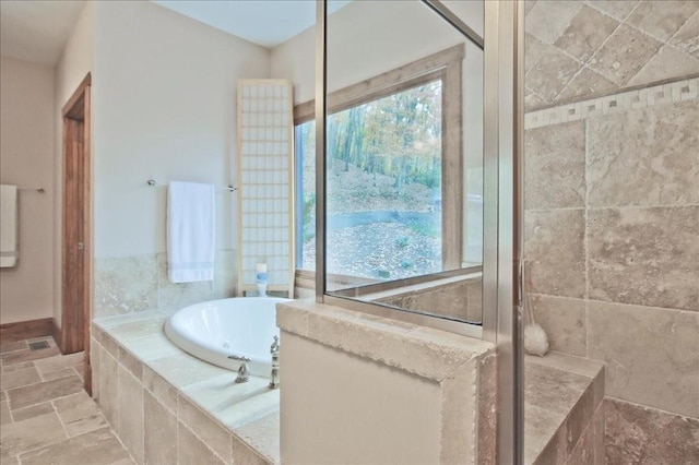 bathroom featuring shower with separate bathtub