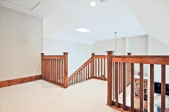 corridor featuring vaulted ceiling and carpet floors