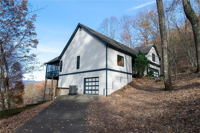 view of side of property with a garage and central air condition unit