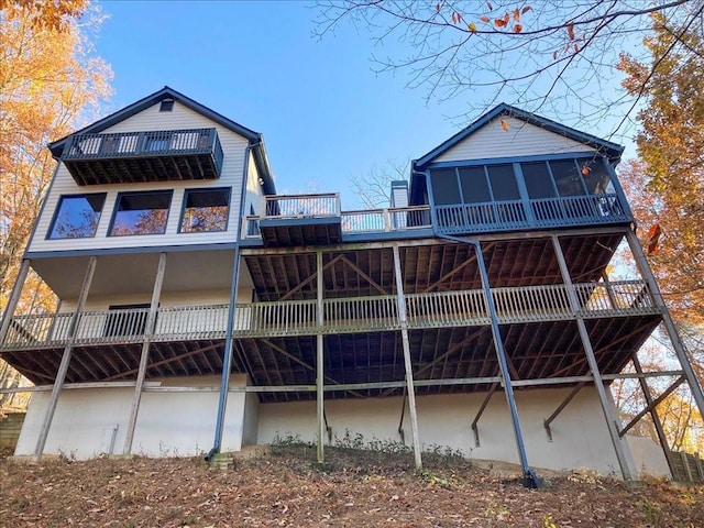 rear view of house with a deck and a sunroom