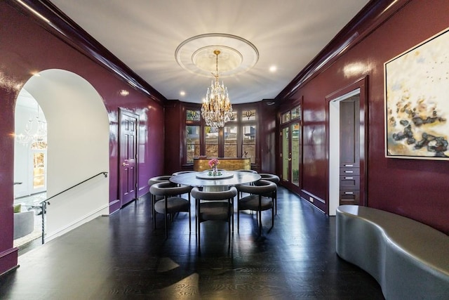 dining area with a chandelier, ornamental molding, baseboards, and wood finished floors