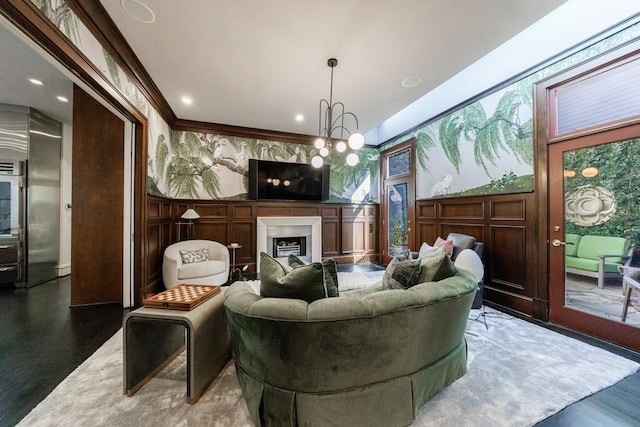 sitting room with wallpapered walls, a notable chandelier, a fireplace, and crown molding