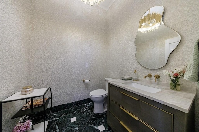 bathroom featuring marble finish floor, baseboards, vanity, and toilet