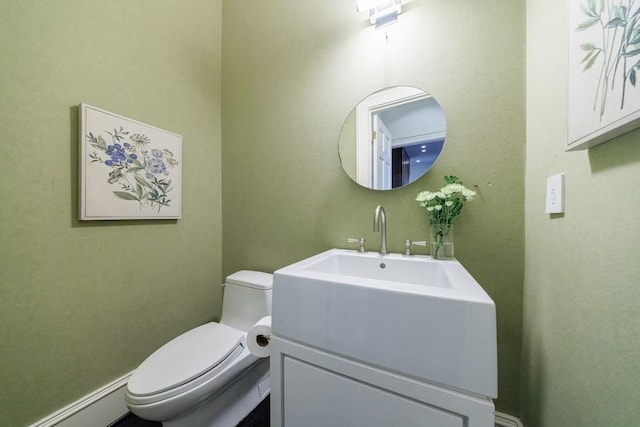 bathroom with baseboard heating, vanity, and toilet