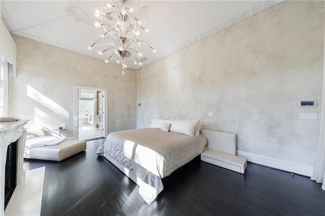 bedroom with ensuite bathroom, an inviting chandelier, and wood finished floors