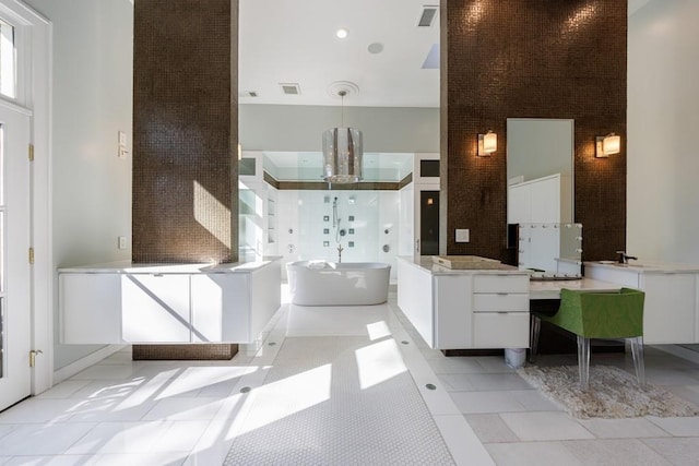 full bathroom with a towering ceiling, a soaking tub, tile patterned flooring, and visible vents