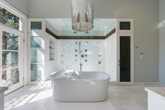 full bathroom featuring tile patterned flooring, a freestanding tub, and tile walls