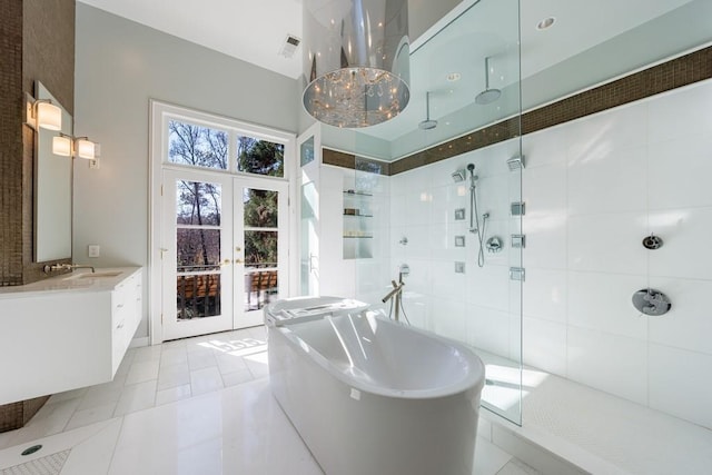 bathroom featuring french doors, visible vents, a freestanding bath, a shower stall, and tile patterned flooring